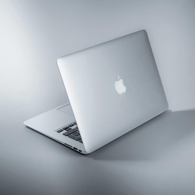silver macbook on white table