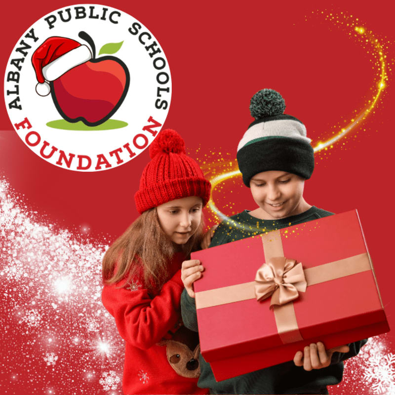Two children hold a large red gift box against a red background featuring a foundation logo and sparkling gold and white accents.