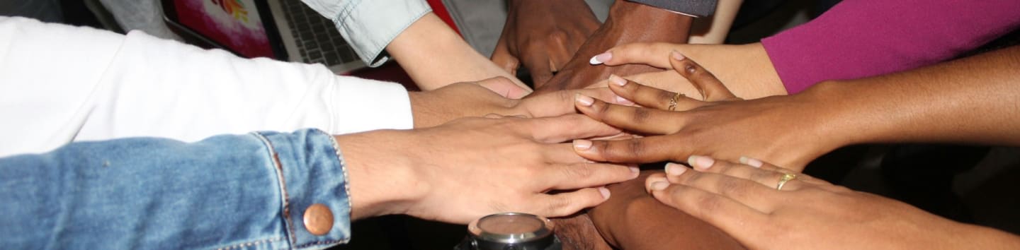 team stacking hands together in unity