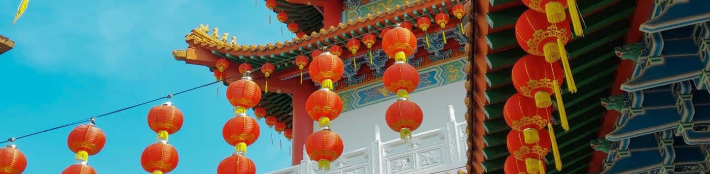 a group of red and yellow lanterns hanging from a roof