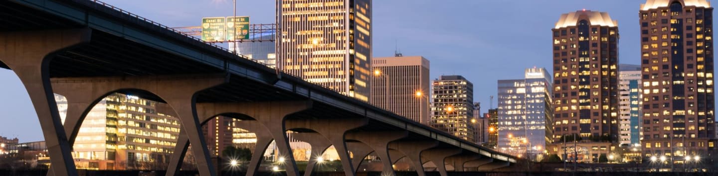 bridge over water near city buildings during night time