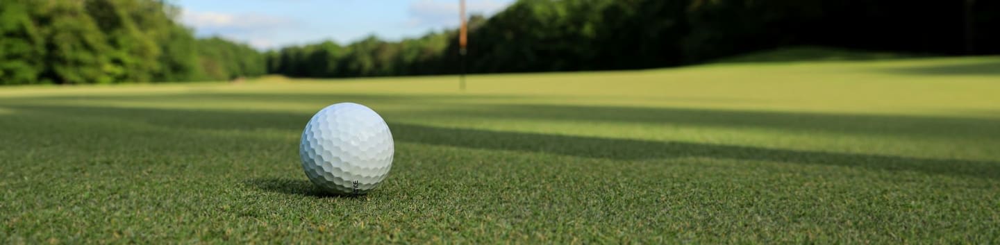 a golf ball sitting on top of a green field