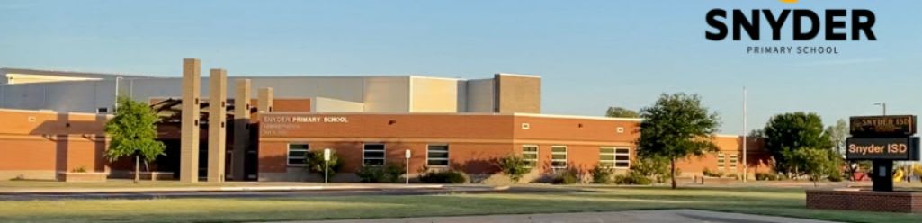 A brick school building with modern architectural elements stands under a clear blue sky, with a sign for "SNYDER PRIMARY SCHOOL" visible in the upper right corner.
