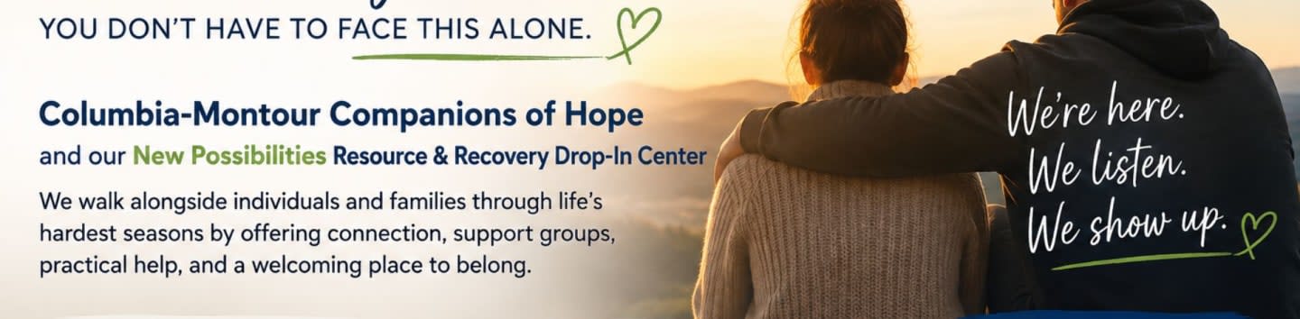 Two people embrace in front of a sunset, with text on the left describing a support center and text on the right of the hoodie reading "We're here. We listen. We show up."