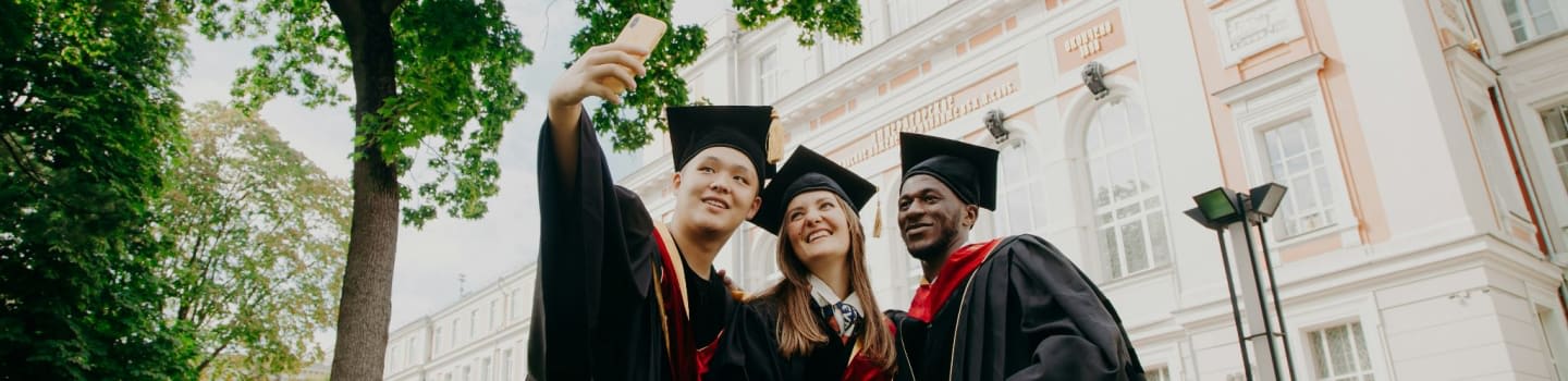 3 women in black academic dress standing near green tree during daytime