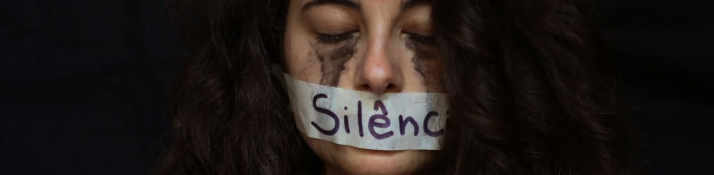 Silence symbolized by tape on a woman's mouth