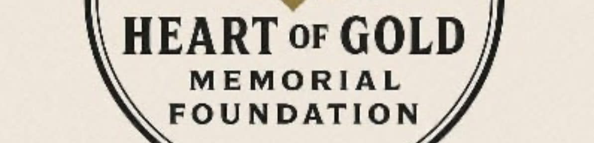 A gold emblem with the text "RYLEE MCCOLLUM HEART OF GOLD MEMORIAL FOUNDATION" and a feather and heart design is centered on a textured, light beige background.