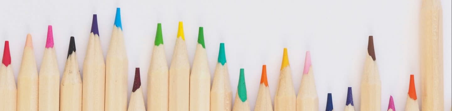 colored pencil lined up on top of white surface