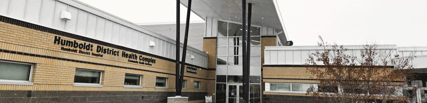 The Humboldt District Health Complex building stands in the foreground against a pale, overcast sky in the background.