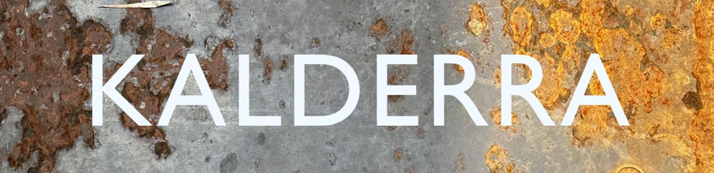 The word "KALDERRA" in white capital letters is centered over a weathered, rusty metal background.