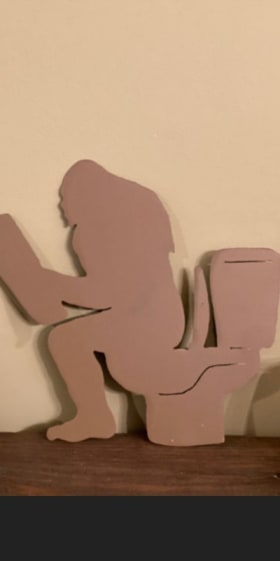 Item #26: Hand-cut Metal Art: Big Foot on Toilet item