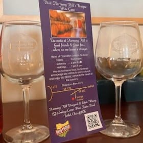 Two bottles of Harmony Hill wine and two HH wine glasses ($1 item