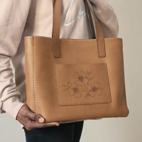 Large leather tote with burned flowers. Brown item
