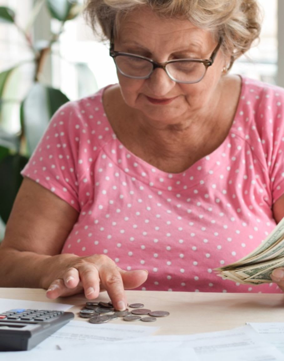 An elderly woman counts her money.