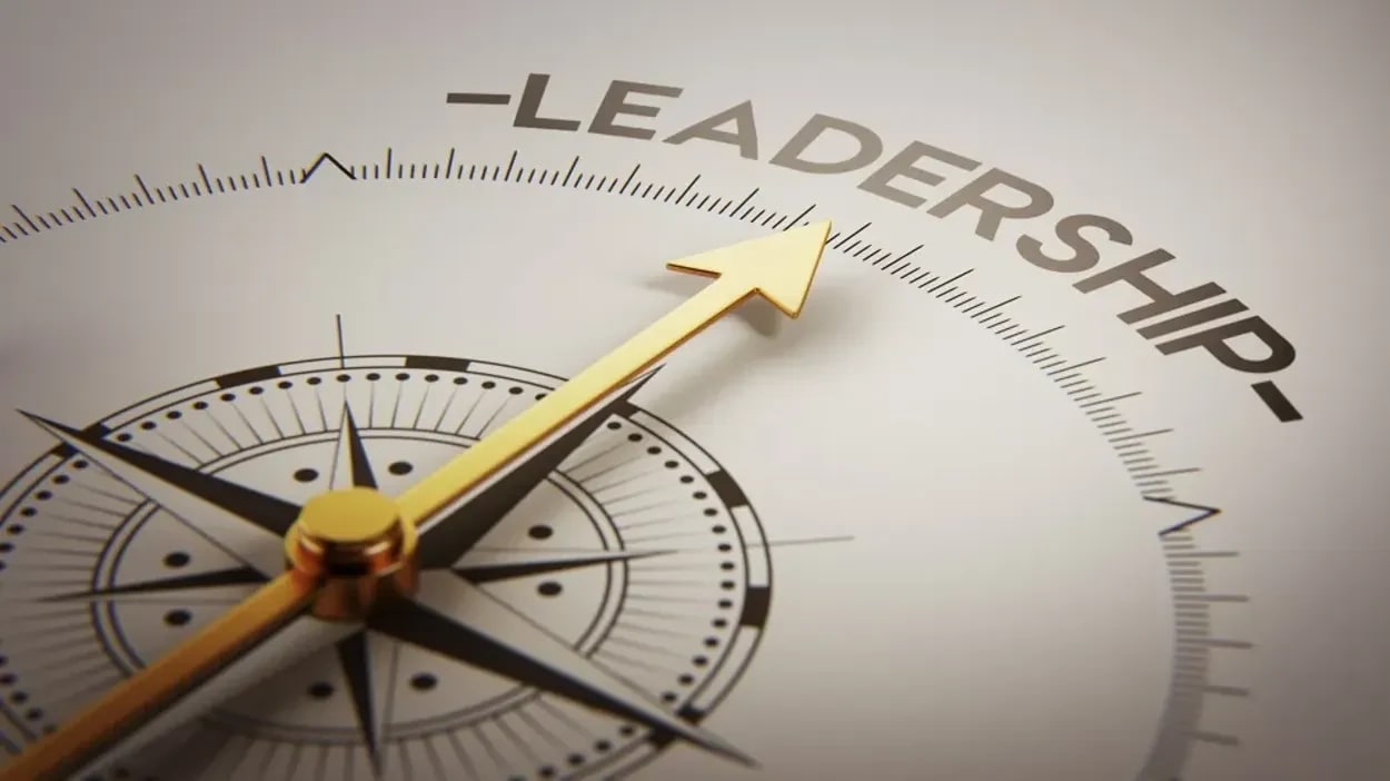 A golden compass needle points towards the word "LEADERSHIP" on a white background.