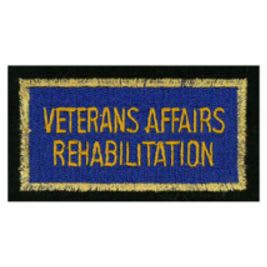 A rectangular patch with a black border, a gold fringe, and a blue center displaying "VETERANS AFFAIRS REHABILITATION" in gold lettering.