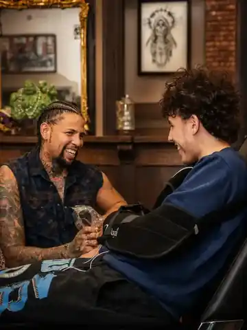 Tony Wulfman talking with a client during a tattoo session