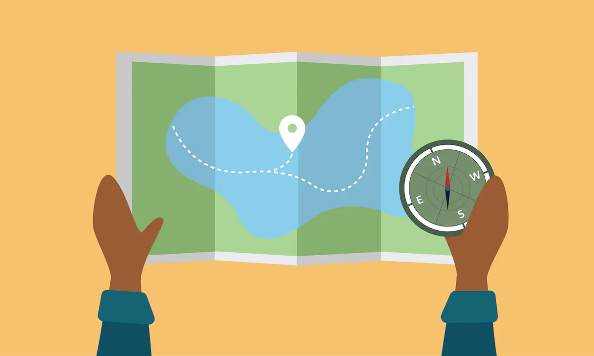A person’s hands holding a map and a compass