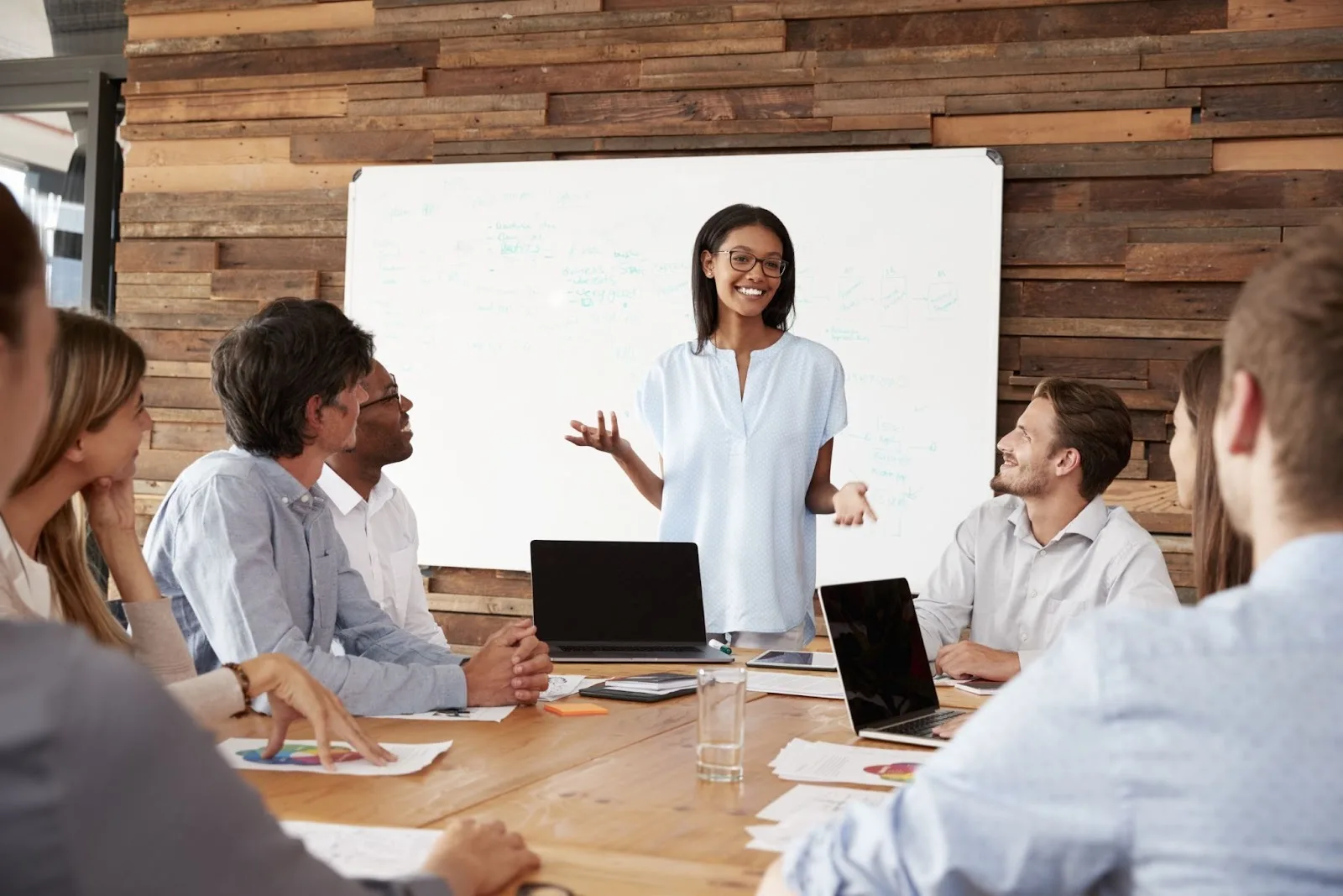 team meeting with person delivering a presentation at the head of the table