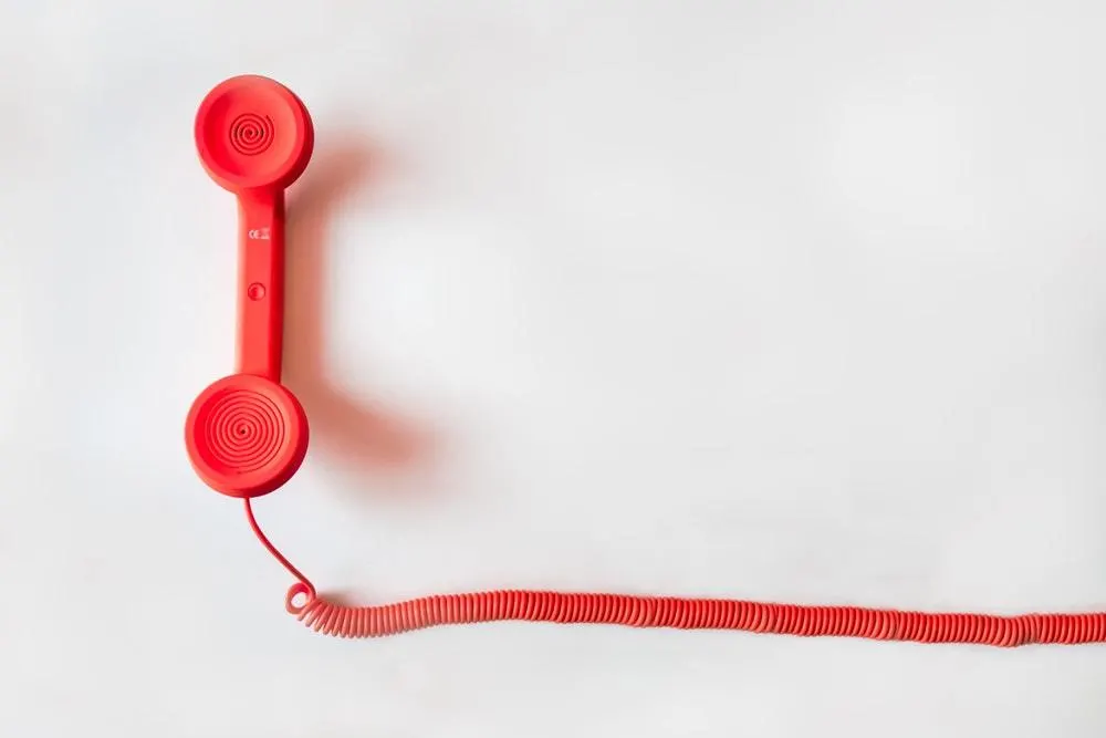 Um telefone vermelho em um fundo branco.