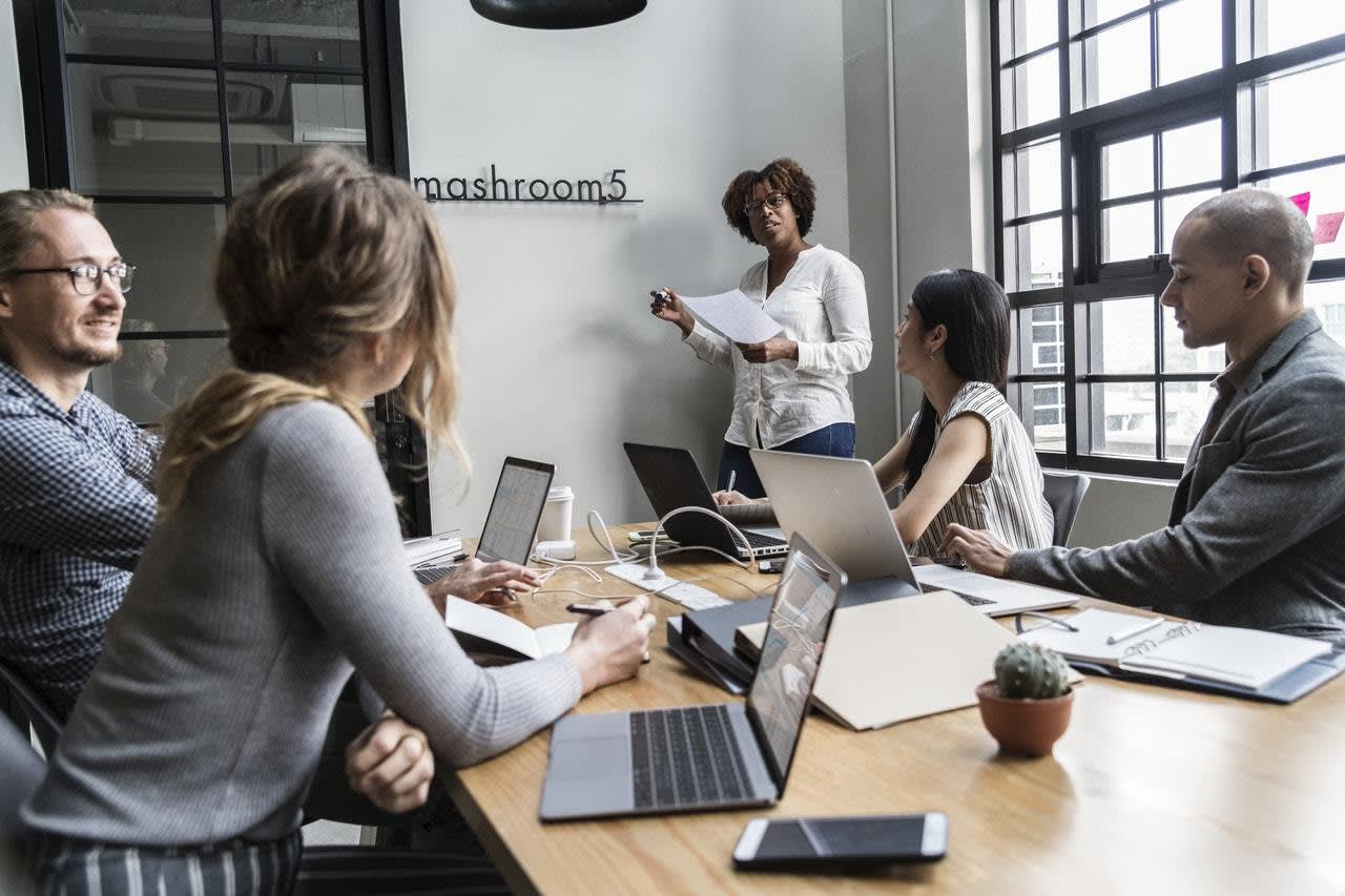 An African-American woman CEO leads a meeting in a boardroom.