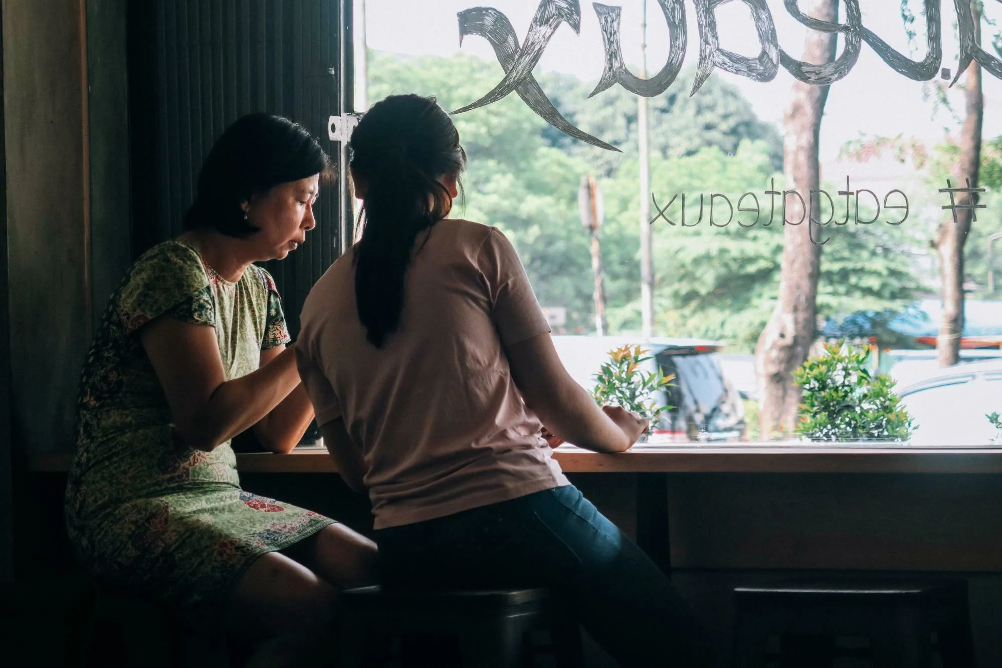 Two people sitting close, discussing, in a cafe