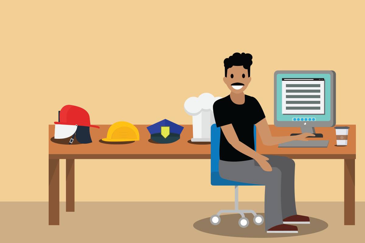 A network security engineer at his desk with various hats on his desk connoting the fact that network security engineers wear many hats given their job responsibilities.