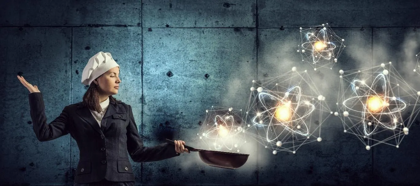 Project manager cooking with atoms of different sizes floating out of the pan