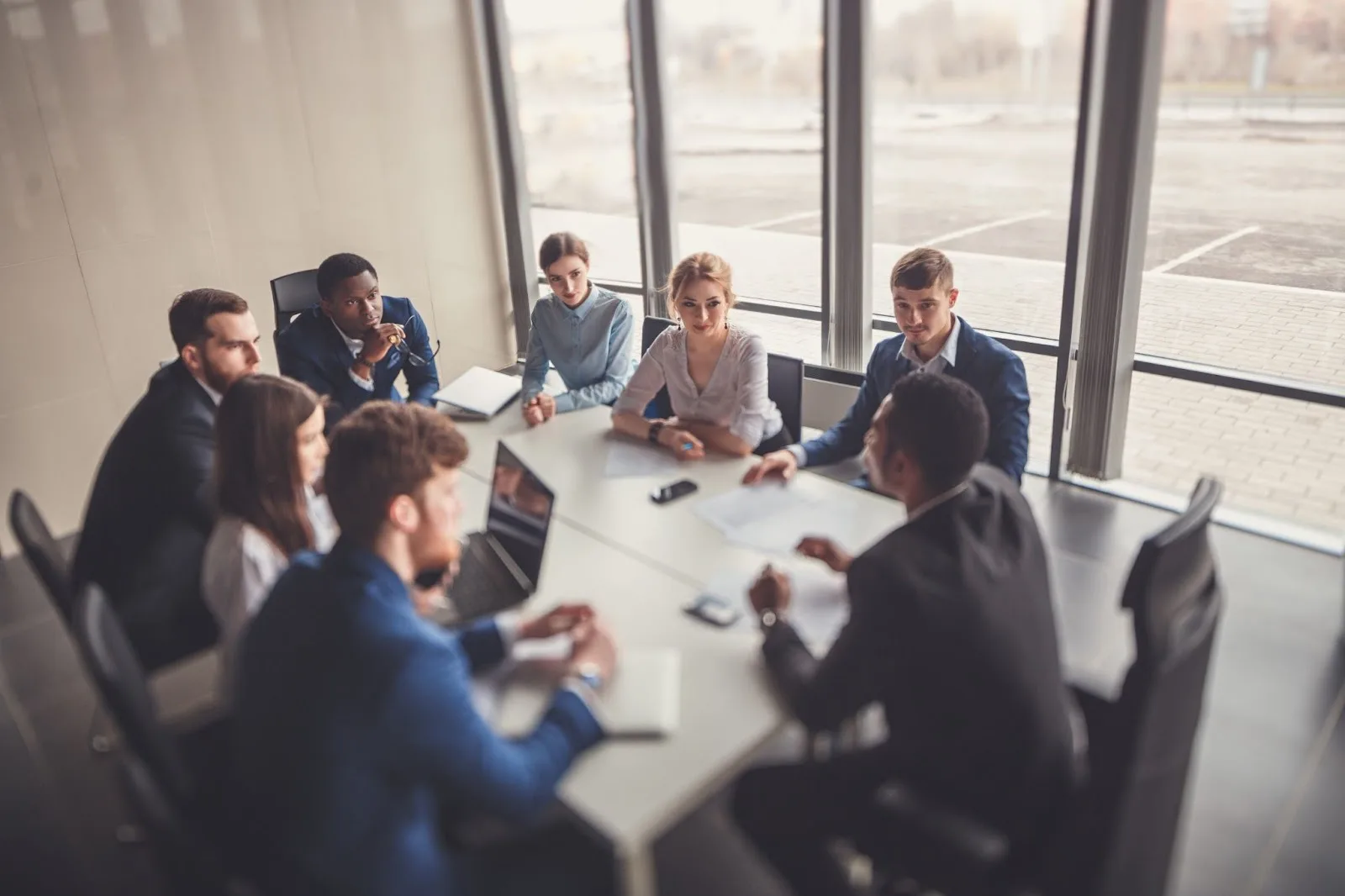 Eight stakeholders meeting in a conference room to get an update on a project.