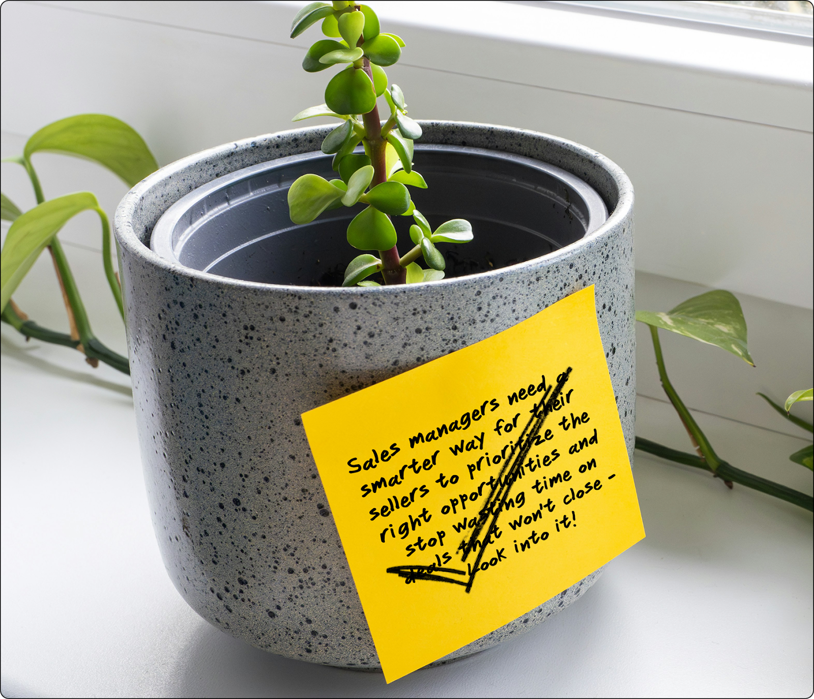 A sticky note about the new feature requirement with a check mark stuck to a potted plant.