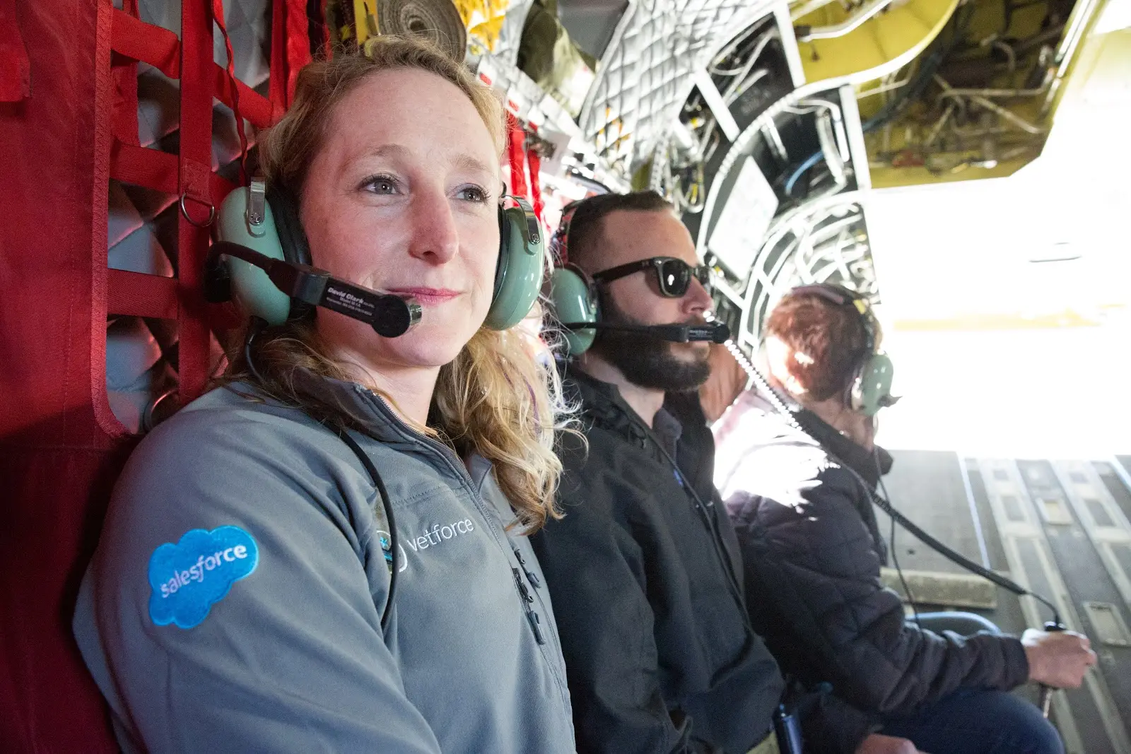 A photo of a veteran wearing a Salesforce jacket on a military aircraft.