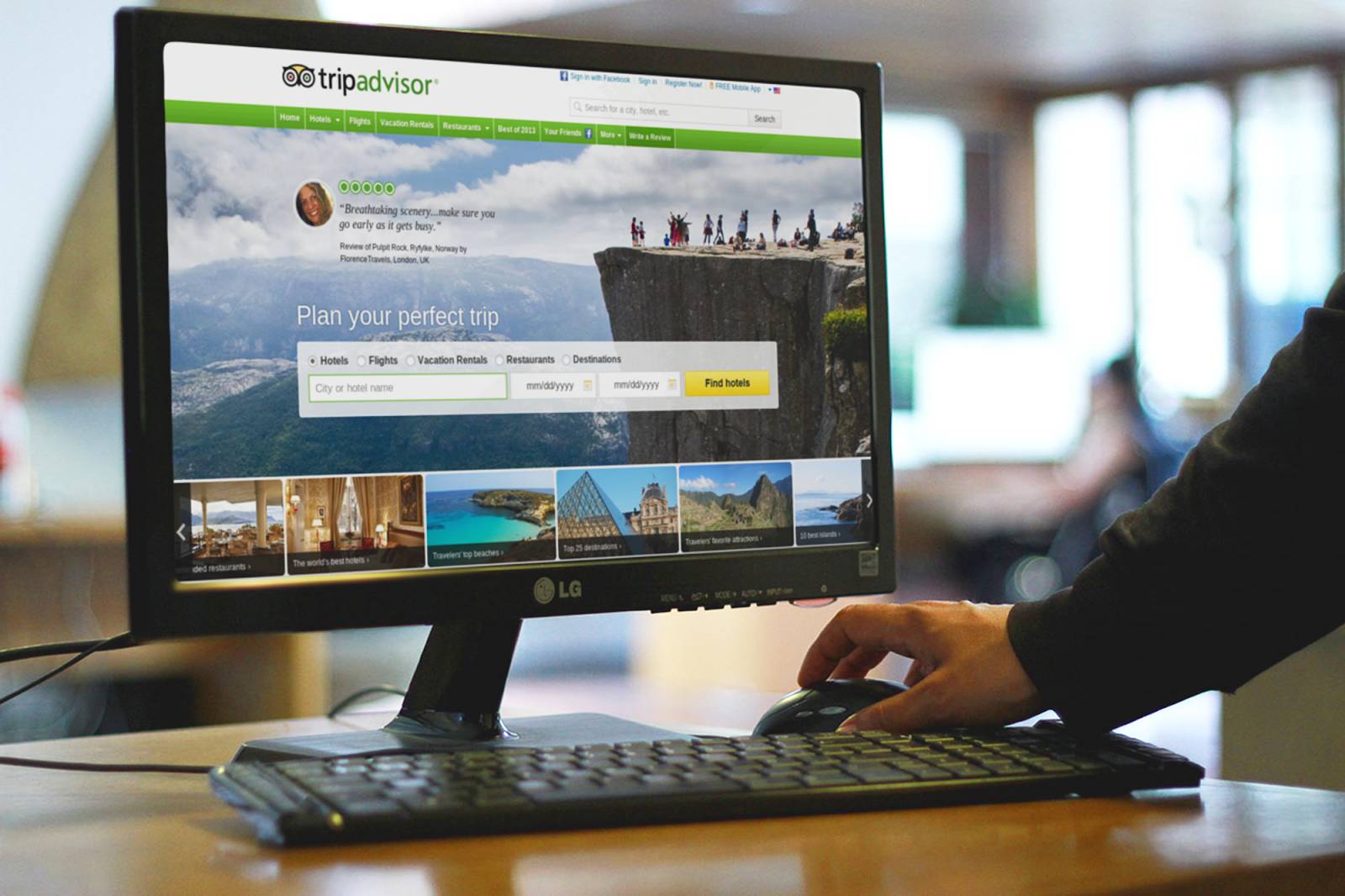 旅行 Web サイトが表示されているコンピューターモニターとキーボード