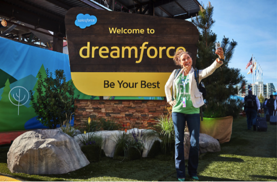 大きな Dreamforce の看板の横で自撮りをする女性。