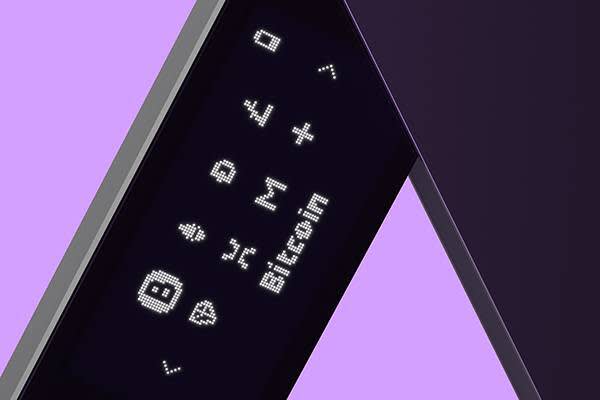 Closeup of Ledger NanoX hardware wallet with multiple blockchain icons on its screen, Bitcoin is selected.