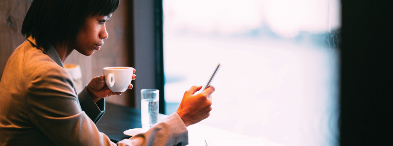 Person checking mobile device at coffee.