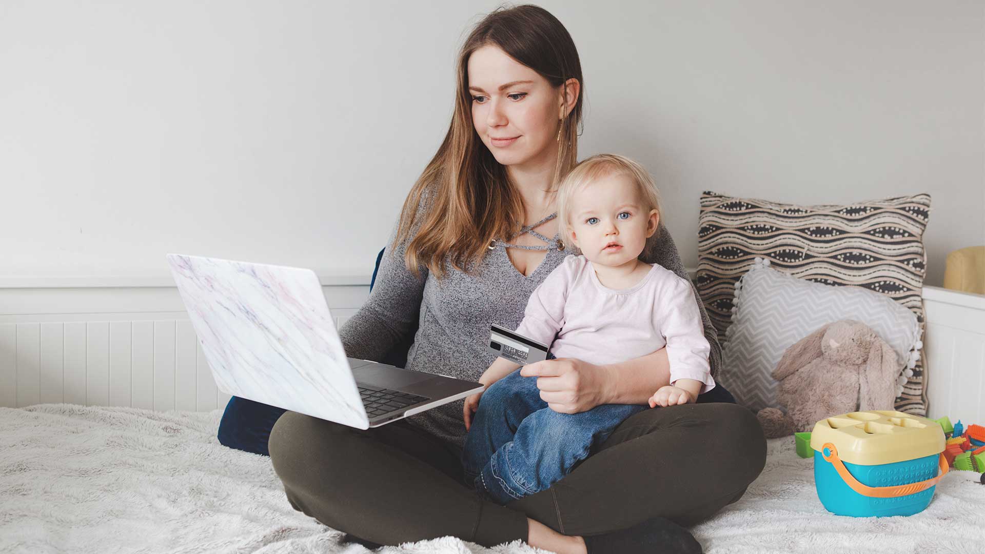 headermoney woman with baby and computer