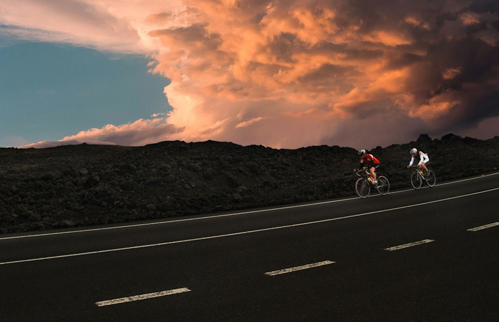 Two cyclists go on a bike workout outdoors after cross-training with rowing.