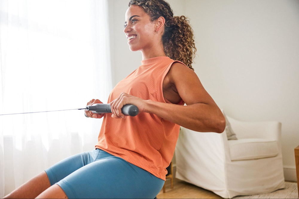 Woman uses a rowing machine to cross-train with other sports.