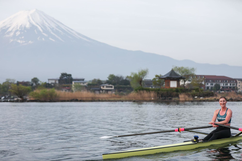 Hydrow Athlete leads an on-water workout for Hydrow rowing machines from beautiful Japan, with Mount Fuji in the background.