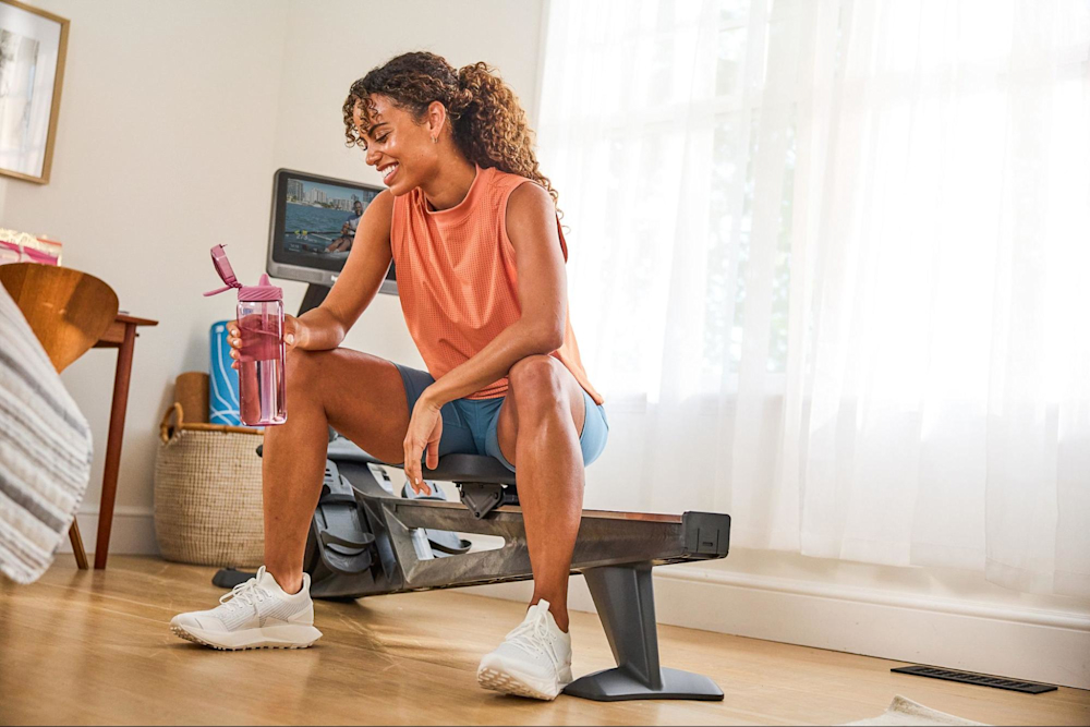 Woman smiles after doing a Hydrow rowing machine workout.