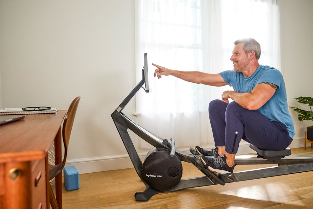 Man gets ready to work out on a Hydrow rowing machine.