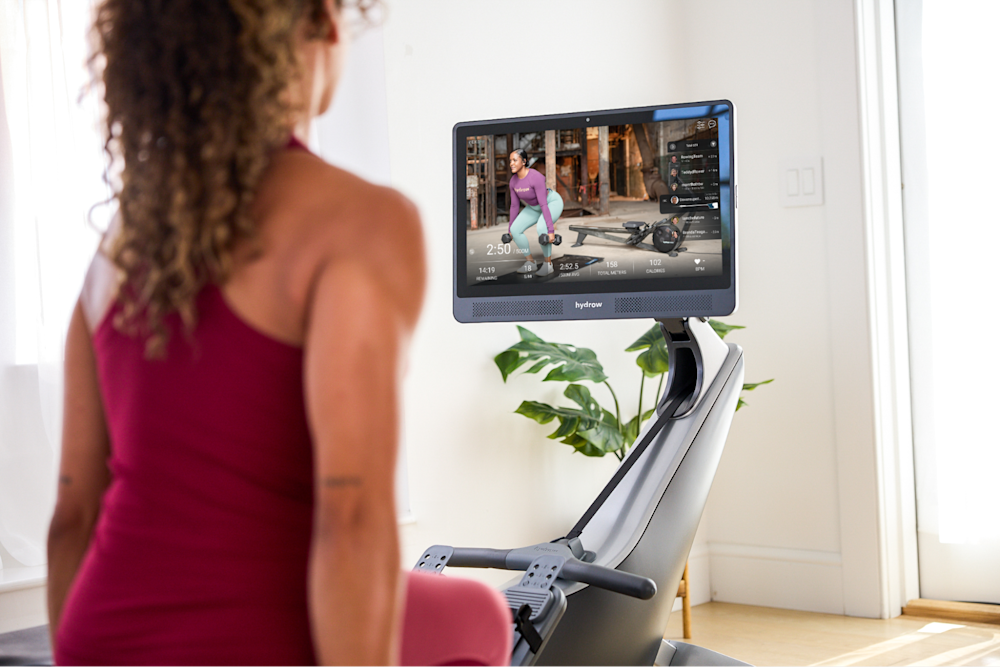 Woman does a workout looking at her swiveled Hydrow screen.