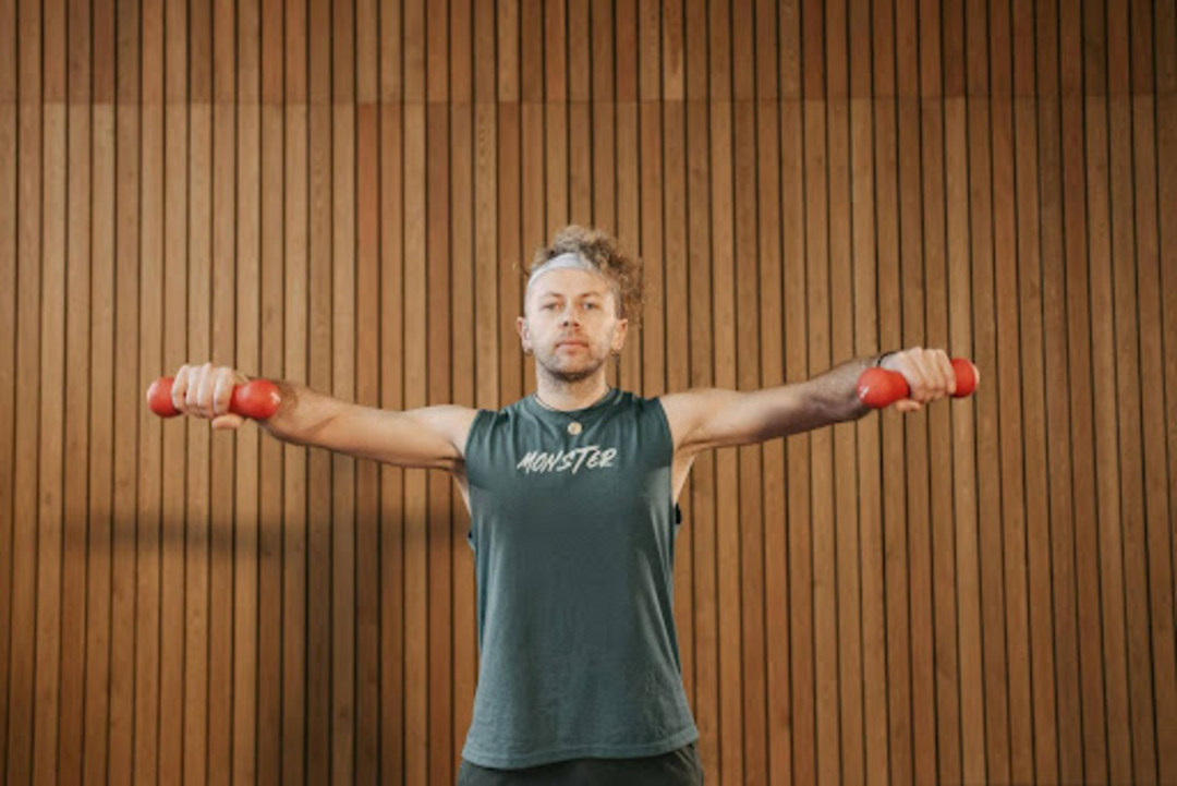 Man does the best dumbbell workouts for beginners in a gym.