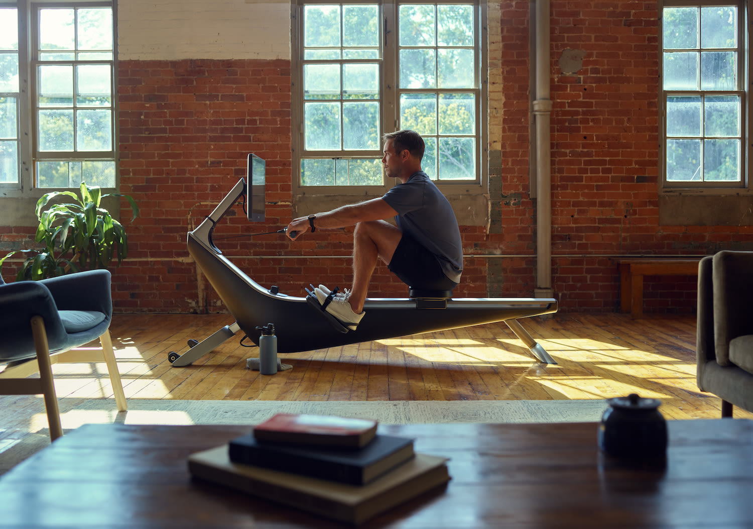 Man works out on his Hydrow rowing machine at home.