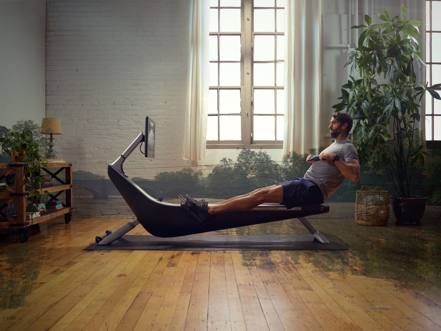 Man works out on his Hydrow rowing machine at home after understanding how long you should work out on a rowing machine.