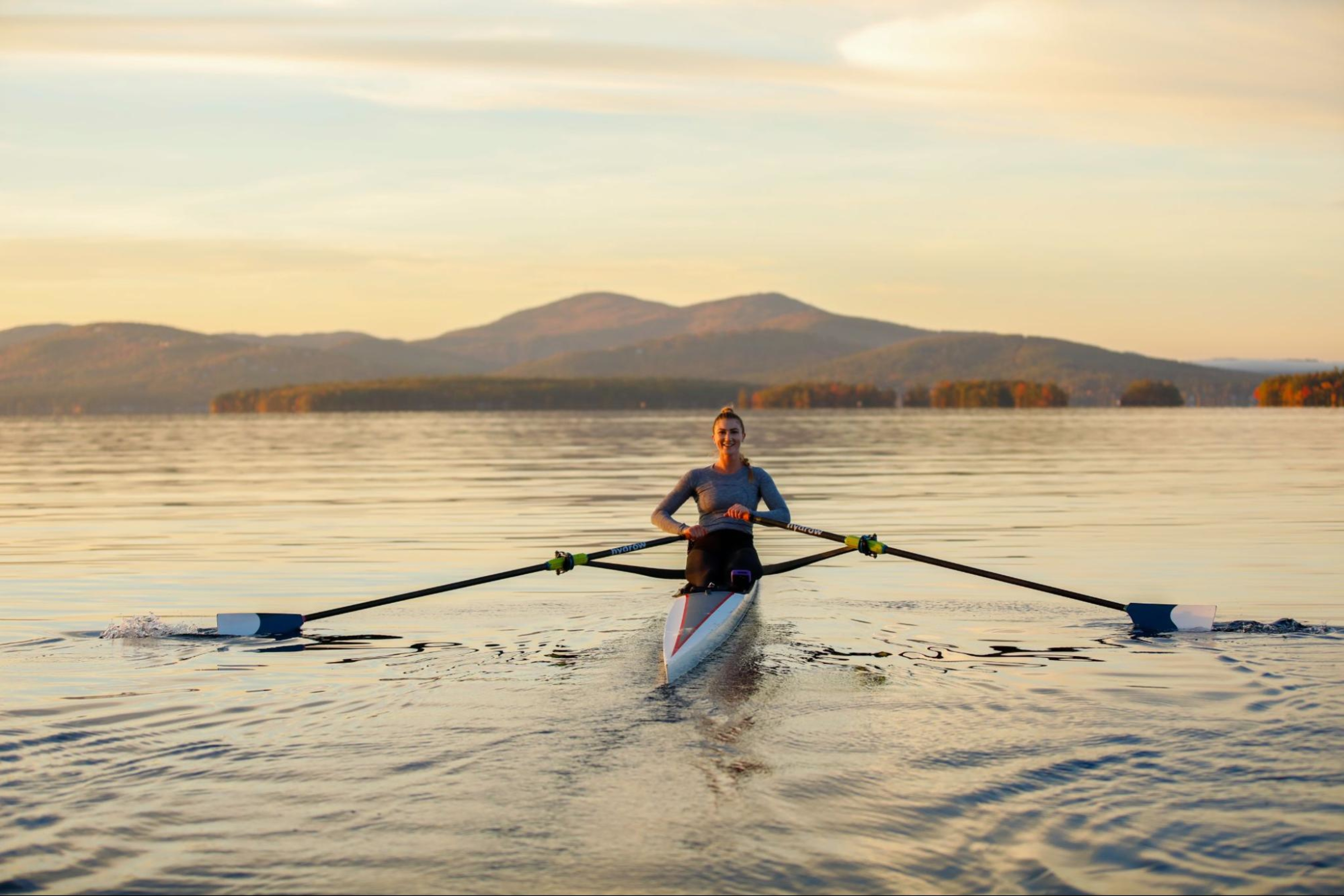 Woman rows on the water as she tries to improve her split time in rowing.