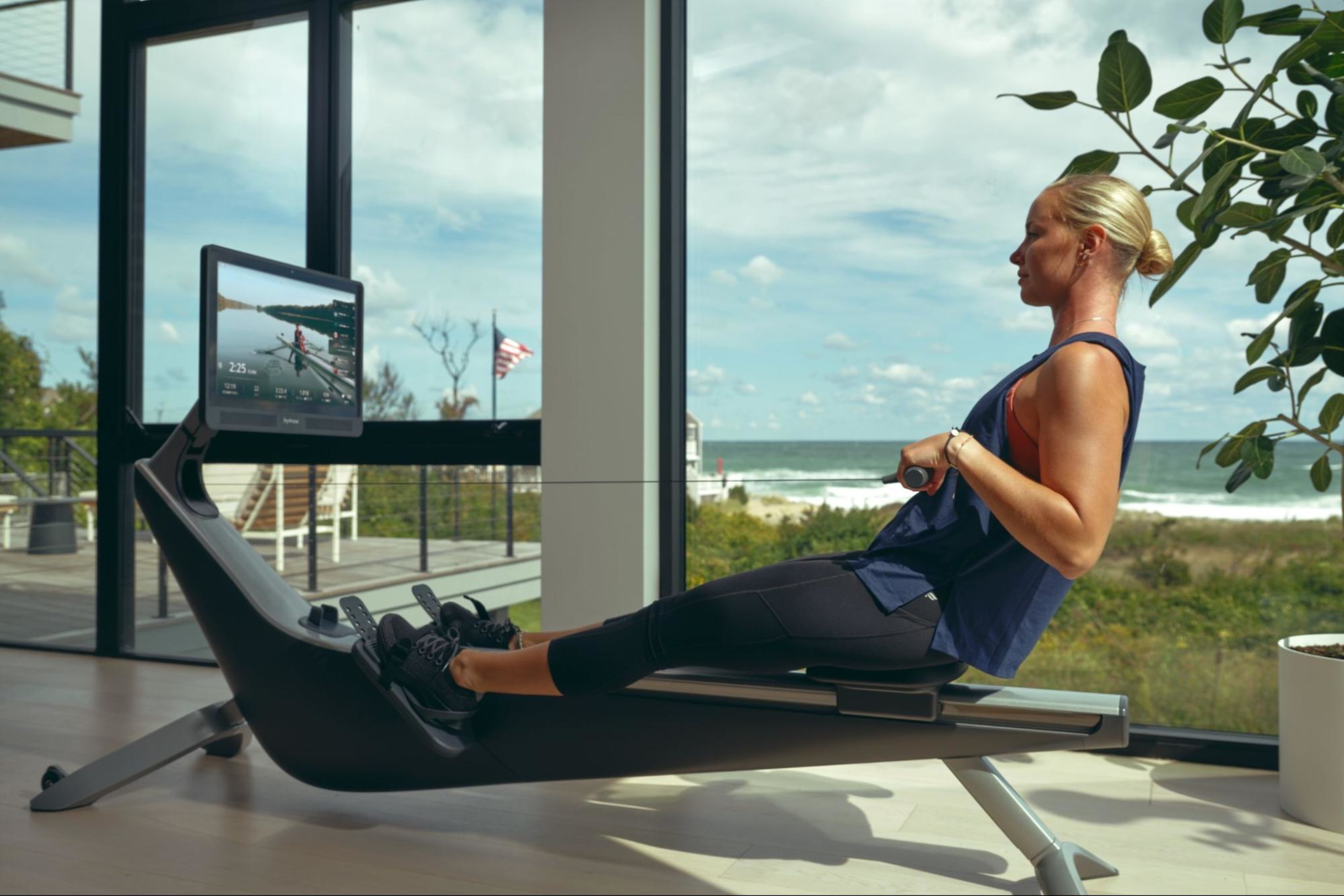 Woman works out on a rowing machine after learning what a rowing machine does for her body.