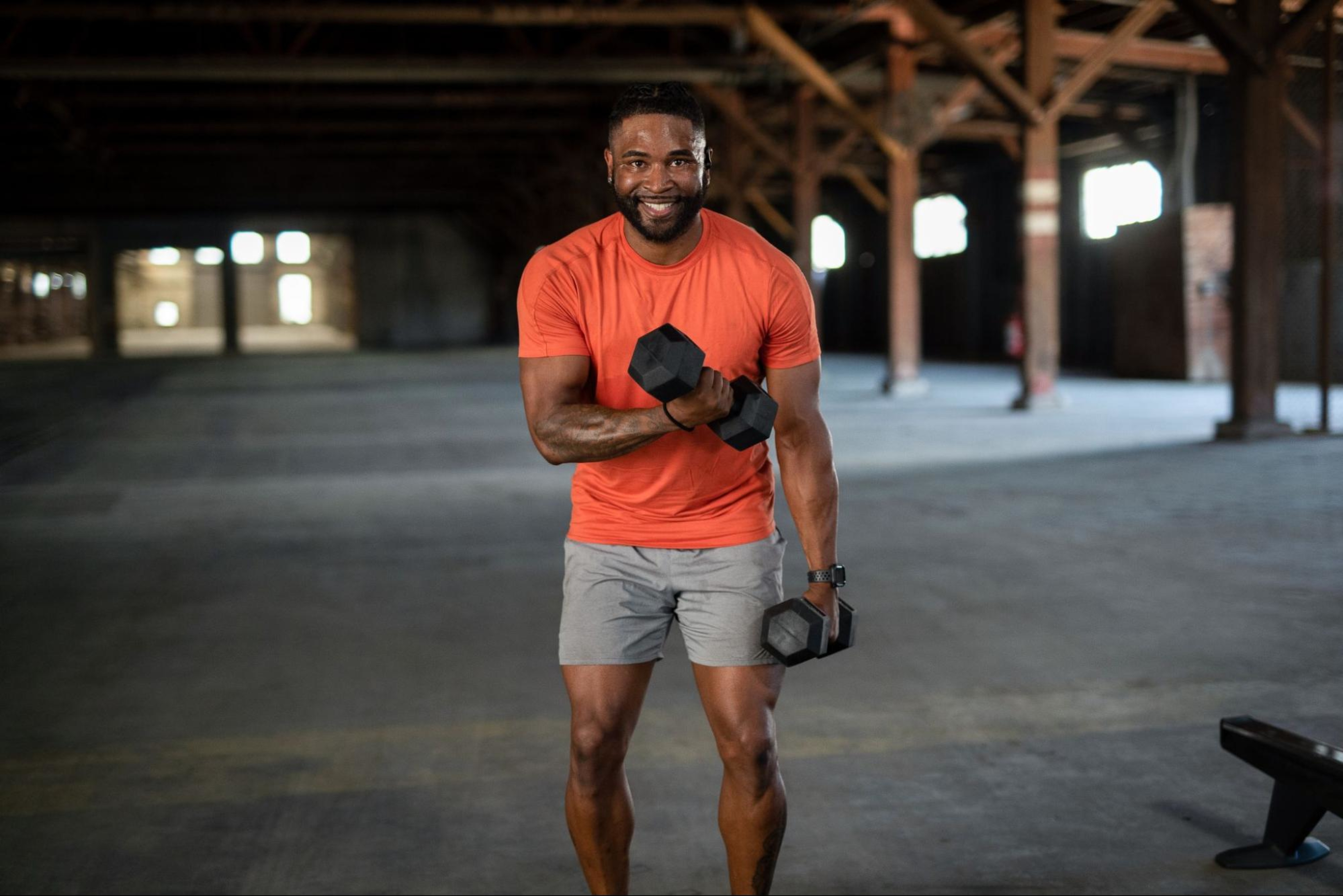 Man uses weights, known as being some of the best home exercise equipment for your home gym.