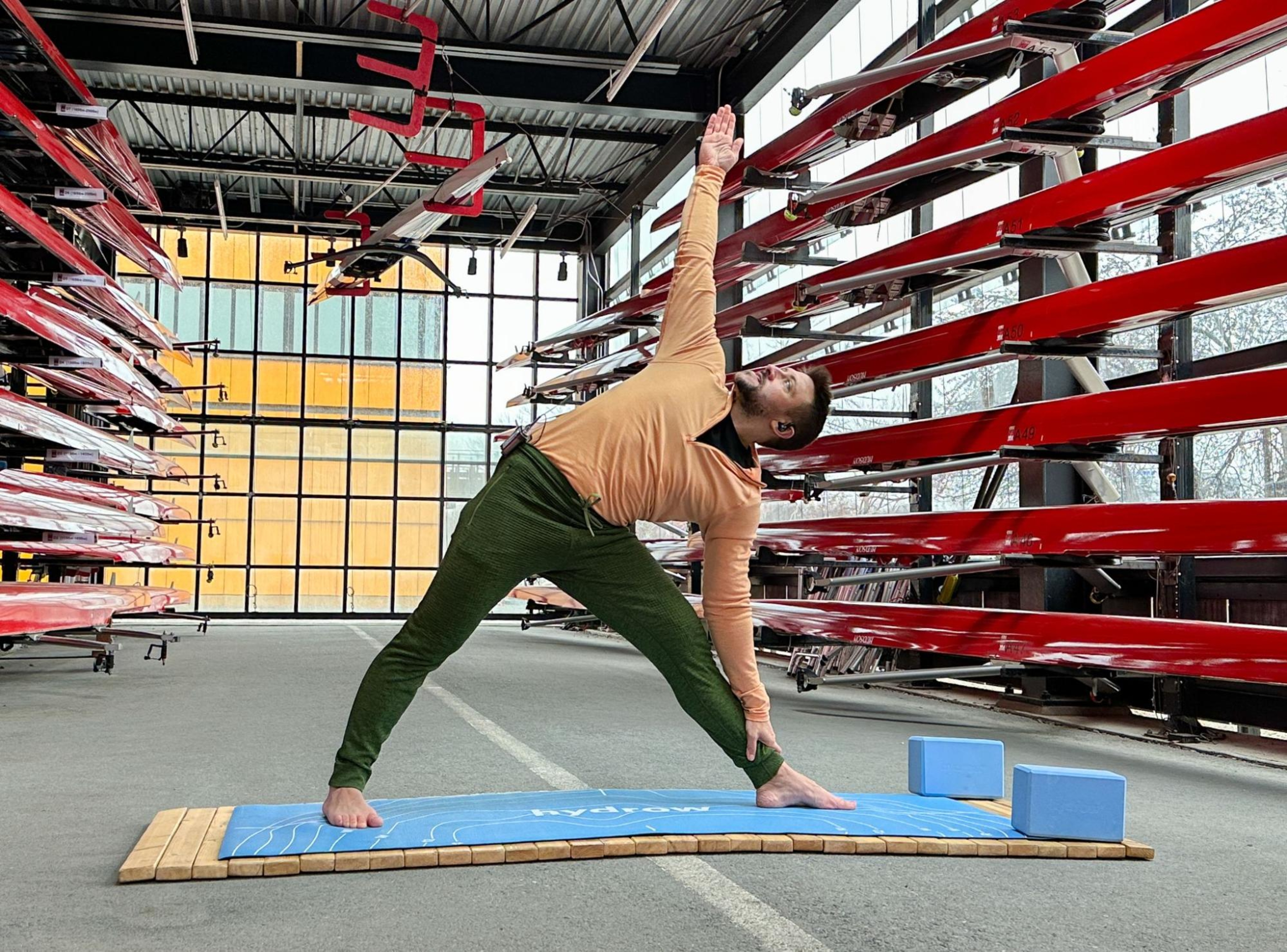 Man does yoga with a yoga mat and blocks, known as some of the best pieces of home exercise equipment.