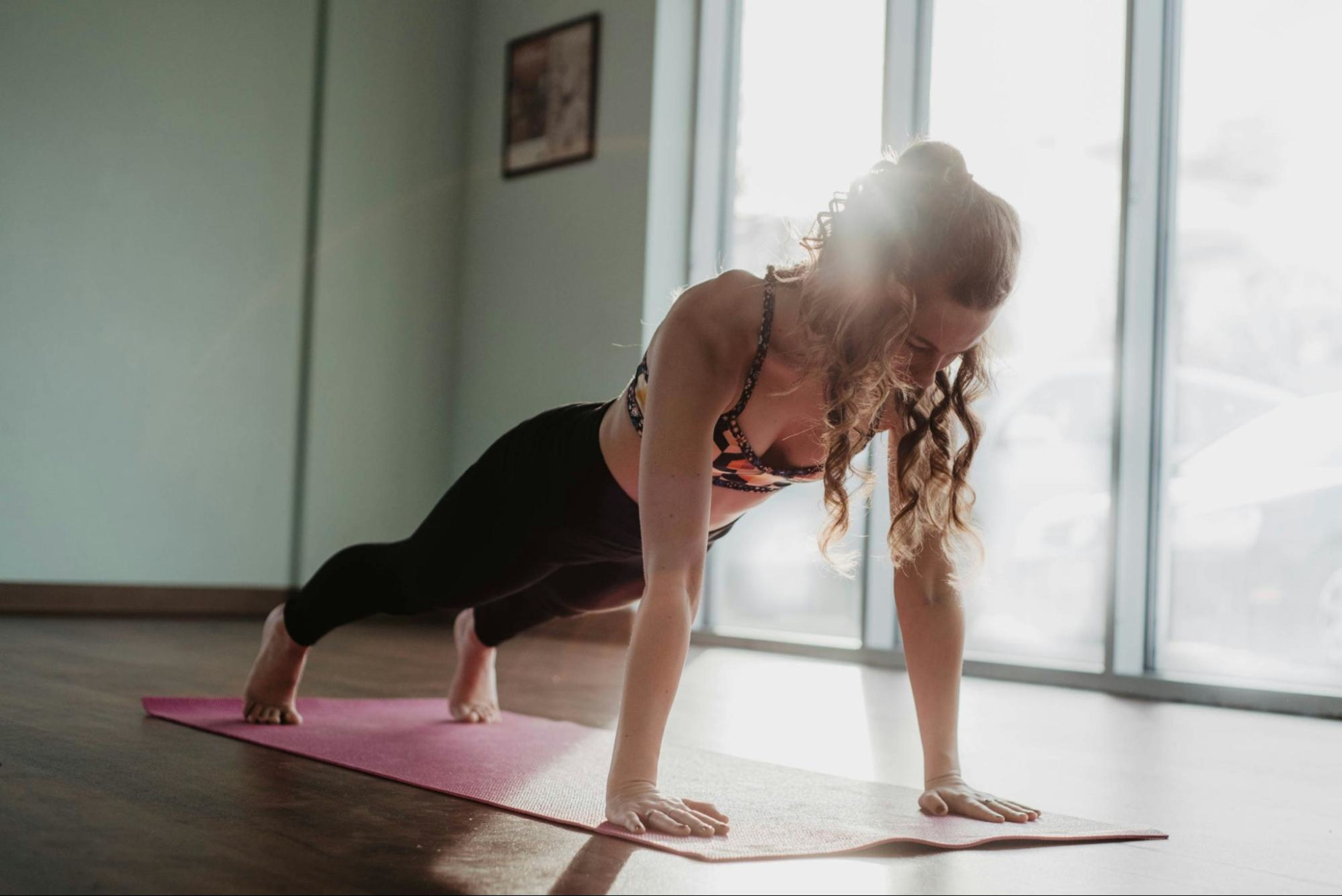 Woman does a plank as part of a 30-minute HIIT workout without equipment.